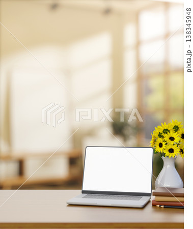 White screen laptop with books and sunflower vase on wooden counter table in the room with sunlight. White screen laptop with books and sunflower vase on wooden counter table in the room with sunlight. 138345948