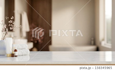 White towel with diffuser and skincare on shiny marble counter table across tub in a modern bathroom 138345965