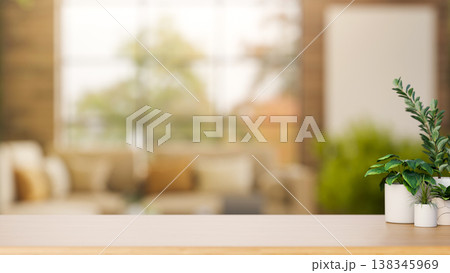 Potted plants on wooden counter table across sofa and glass window in a blurred living room or cafe. 138345969