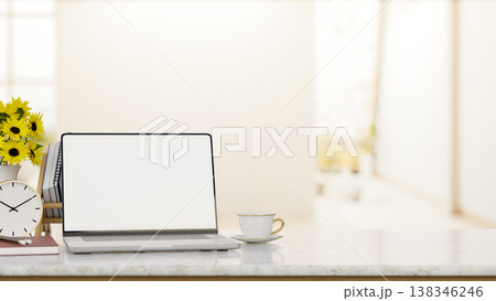White screen laptop and coffee with clock and sunflower vase on marble counter table in bright room. 138346246