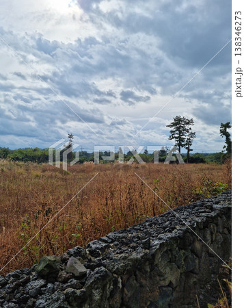 Grassland with cloudy sky and stone wall. Grassland with cloudy sky and stone wall. 138346273