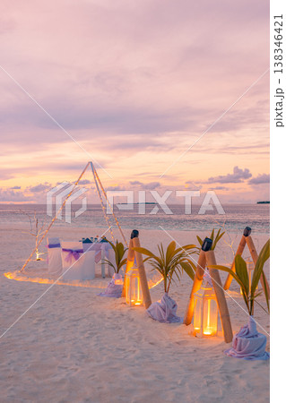 Romantic beach dinner with candles and artistic table setting, ocean view summer honeymoon wedding anniversary outdoor design background 138346421