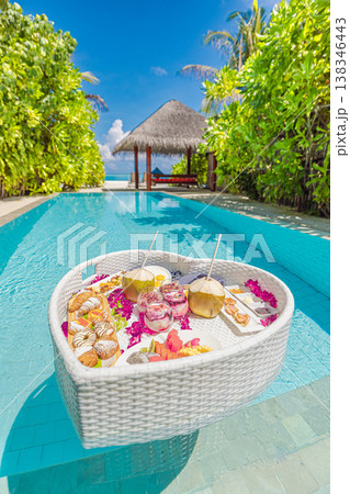 Luxury hotel swimming pool with floating breakfast tray, romantic couple enjoying sunshine, exotic private pool design, love and leisure background 138346443