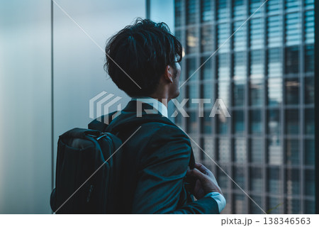 リュックを背負い窓の外を見る男性 138346563