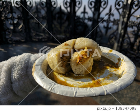 Close-up of traditional Himachali Sittu served on a paper plate, showing stuffed steamed bread with local spices, captured outdoors in natural sunlight. Close-up of traditional Himachali Sittu served on a paper plate, showing stuffed steamed bread with local spices, captured outdoors in natural sunlight. 138347098