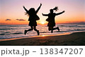 夕暮れの海岸でジャンプする制服姿の女子高校生のシルエット 138347207
