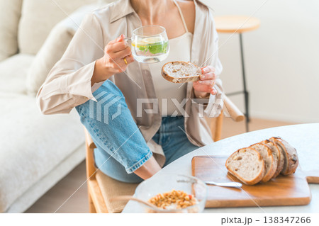 ダイニングテーブルで朝食をとる若いアジア人女性 ダイニングテーブルで朝食をとる若いアジア人女性 138347266