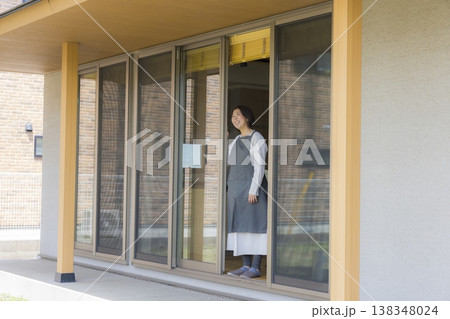 窓から外を眺める女性 138348024
