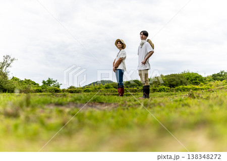 田園風景の中で立つ若い農家 138348272