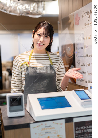 決済端末を案内するエプロン姿の女性 決済端末を案内するエプロン姿の女性 138348600