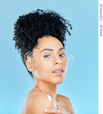 Beauty, studio portrait and woman with body cream application, dermatology product or lotion for skin hydration glow. Spa salon wellness, shoulder creme and aesthetic model shine on blue background Beauty, studio portrait and woman with body cream application, dermatology product or lotion for skin hydration glow. Spa salon wellness, shoulder creme and aesthetic model shine on blue background 138349226