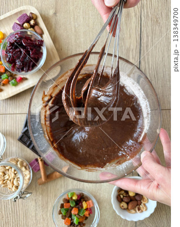 Women's hands whisking chocolate dough in a glass bowl. Top view. 138349700