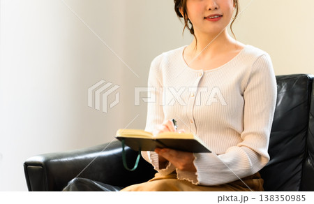ノートに何かを書き込む女性 138350985