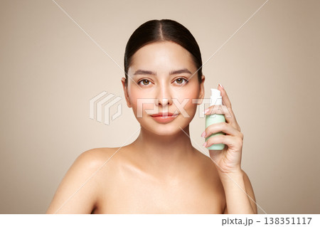 Beautiful woman with bottle of moisturizer cream Beautiful woman with bottle of moisturizer cream 138351117