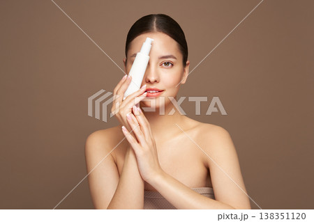 Beautiful woman with bottle of moisturizer cream Beautiful woman with bottle of moisturizer cream 138351120