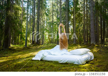 Girl wakes up in a summer forest 138351150