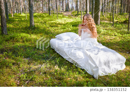 Young woman has breakfast in bed in a summer forest Young woman has breakfast in bed in a summer forest 138351152