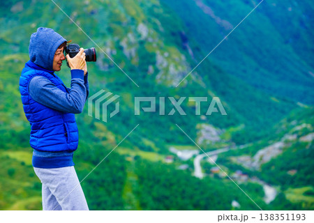 Tourist with camera and in Norway mountains Tourist with camera and in Norway mountains 138351193