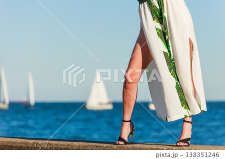 Woman feet in high heels shoes on sea pier Woman feet in high heels shoes on sea pier 138351246