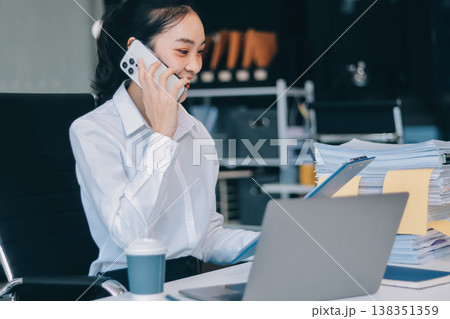 Charming smiling adult woman middle aged woman with curly hair architect designer working on computer in the bright modern office Charming smiling adult woman middle aged woman with curly hair architect designer working on computer in the bright modern office 138351359
