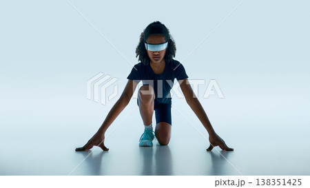 Teen athlete in starting pose wearing reflective futuristic visor in minimal studio background. Teen athlete in starting pose wearing reflective futuristic visor in minimal studio background. 138351425