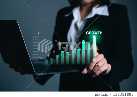 Business Success and Growth Concept with Graphs Presented by a Professional Woman Holding a Laptop in Formal Attire Business Success and Growth Concept with Graphs Presented by a Professional Woman Holding a Laptop in Formal Attire 138351895