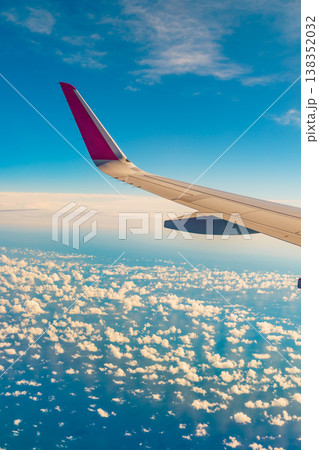 View from an airplane window to wing and clouds 138352032