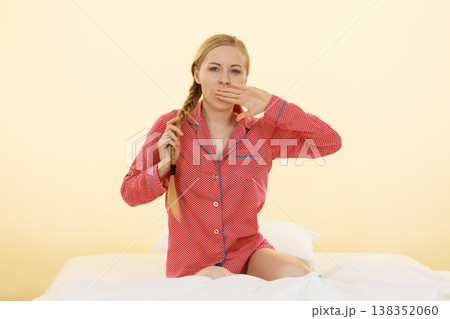 Sleepy young woman wearing cute pink pajamas Sleepy young woman wearing cute pink pajamas 138352060
