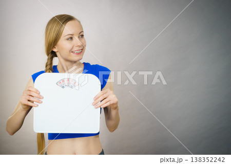 Teenage woman holding bathroom scale machine 138352242