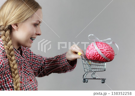 Woman holding shopping cart with brain 138352258