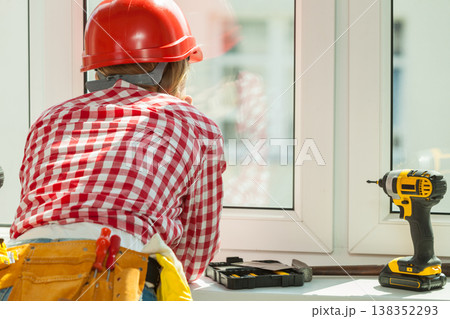 Woman with helmet next to the window Woman with helmet next to the window 138352293