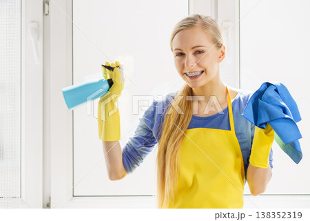 Woman cleaning window at home 138352319
