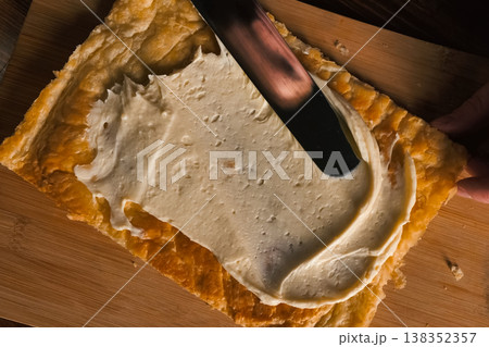 Smearing the cream over the layers of cake dough. Pie filling. 138352357
