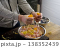 Squeezing lemons in a plate with chicken meat. lemon 138352439
