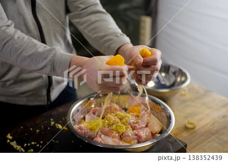Squeezing lemons in a plate with chicken meat. lemon Squeezing lemons in a plate with chicken meat. lemon 138352439