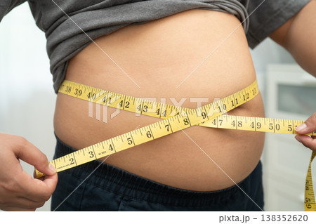 Asian woman with fat belly big size overweight and obesity with measure tape. 138352620