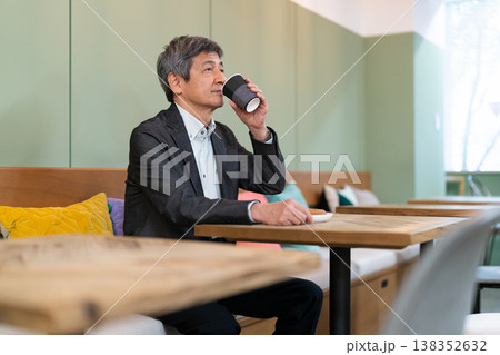 カフェでコーヒーを飲みながらリラックスするシニアビジネスマン カフェでコーヒーを飲みながらリラックスするシニアビジネスマン 138352632