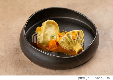 Khinkali dumplings with sauce in black bowl Khinkali dumplings with sauce in black bowl 138352830