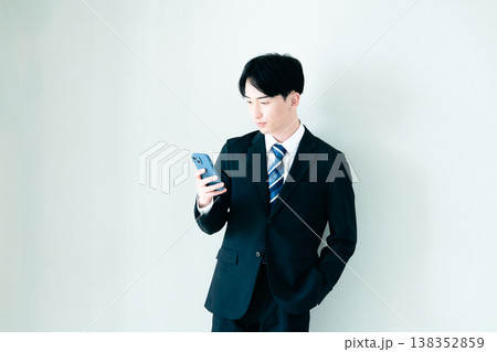 オフィスでスマホを見る若いビジネスマン オフィスでスマホを見る若いビジネスマン 138352859