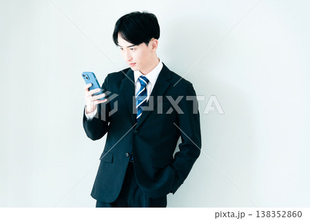 オフィスでスマホを見る若いビジネスマン 138352860