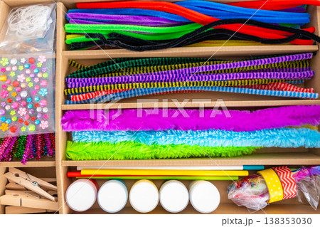 Colorful craft supplies with pipe cleaners stickers and materials arranged in organizer box. Creative play imagination and fine motor skills development concept. 138353030