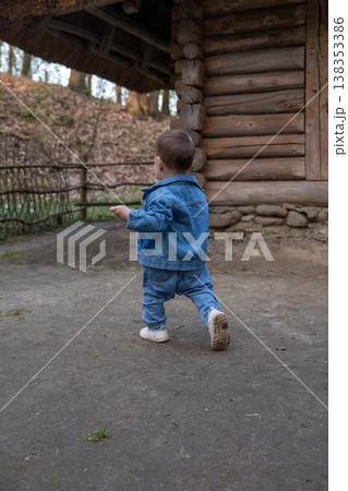 Toddler walking near rustic log cabin outdoors Toddler walking near rustic log cabin outdoors 138353386
