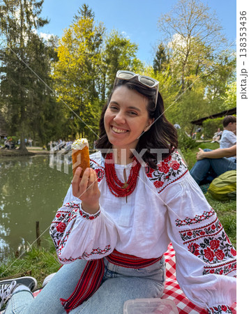 Woman in embroidered blouse enjoying picnic by the lake 138353436