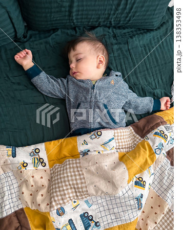 Peaceful sleeping baby under patchwork quilt at home 138353498