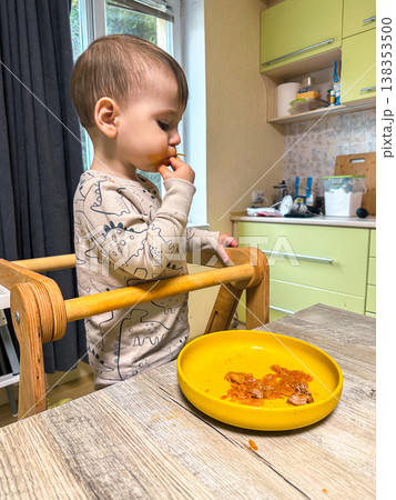 Toddler self-feeding messy meal in high chair Toddler self-feeding messy meal in high chair 138353500