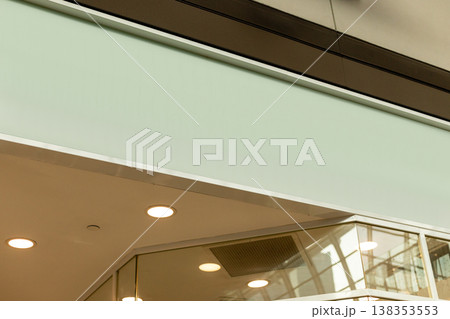 A modern storefront presents an empty space where a logo can be placed. The shop is located in a busy retail area, ready for branding and advertising opportunities 138353553