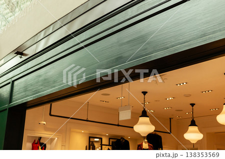 The storefront features a clean design with an empty area for logo placement, suitable for branding. It is located in a busy shopping district with bright lights The storefront features a clean design with an empty area for logo placement, suitable for branding. It is located in a busy shopping district with bright lights 138353569