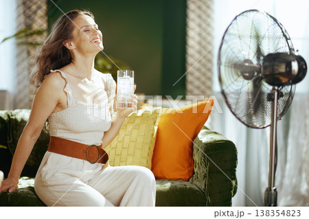 Smiling Woman Enjoys Cool Breeze and Iced Drink 138354823