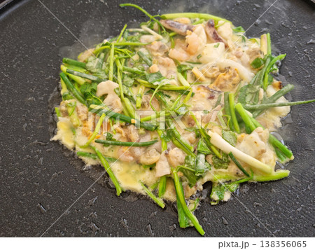 This is water parsley pancake being cooked in a frying pan. 138356065