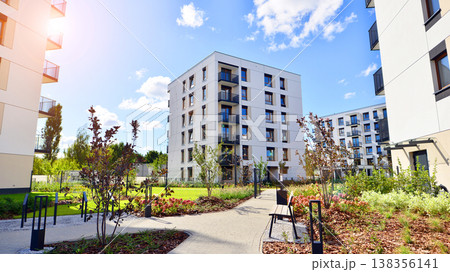 European residential architecture harmonizing with nature. Eco-friendly living in city with greens. Eco apartment building saving energy and fresh air concept. European residential architecture harmonizing with nature. Eco-friendly living in city with greens. Eco apartment building saving energy and fresh air concept. 138356141